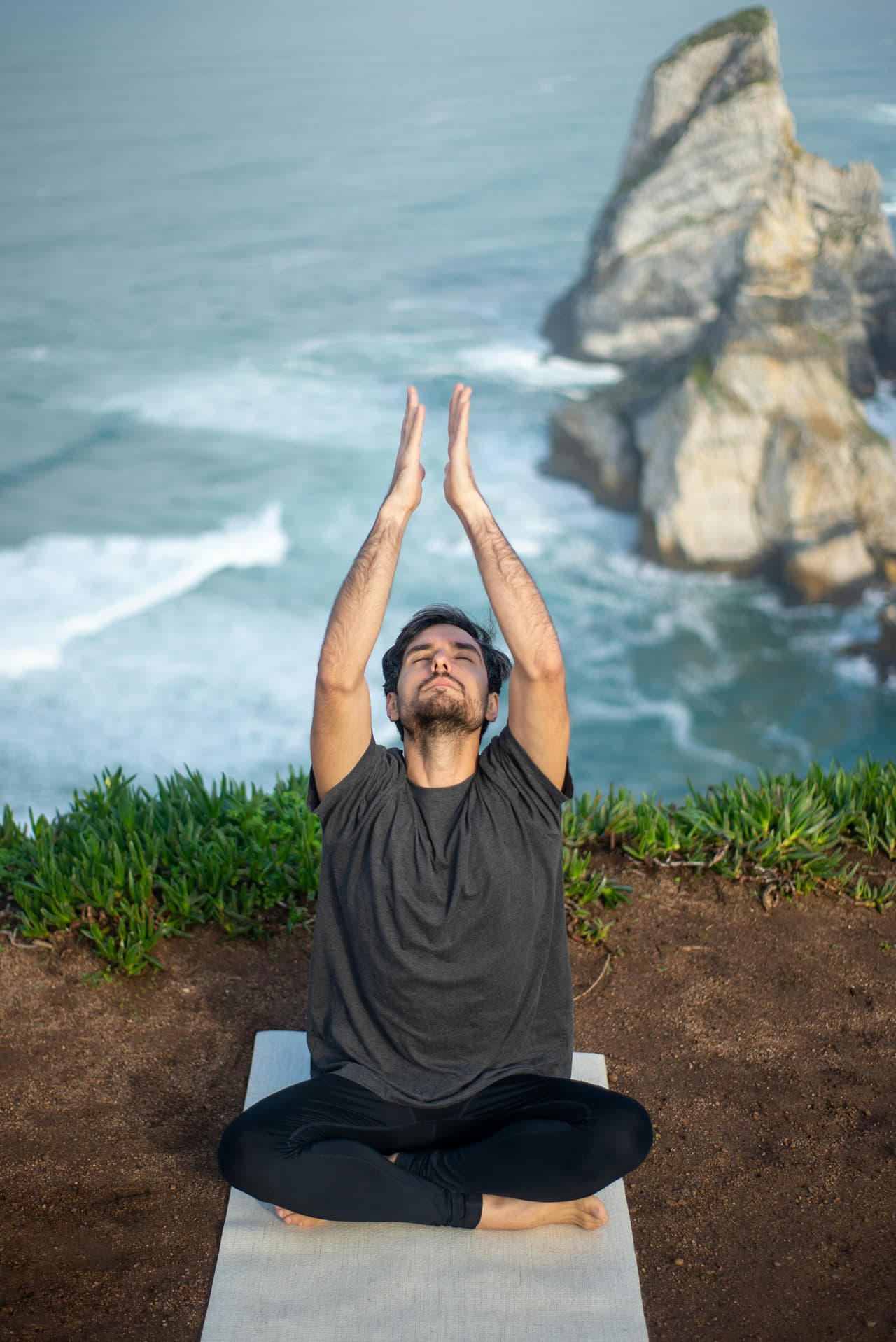 Yoga on cliff by ocean